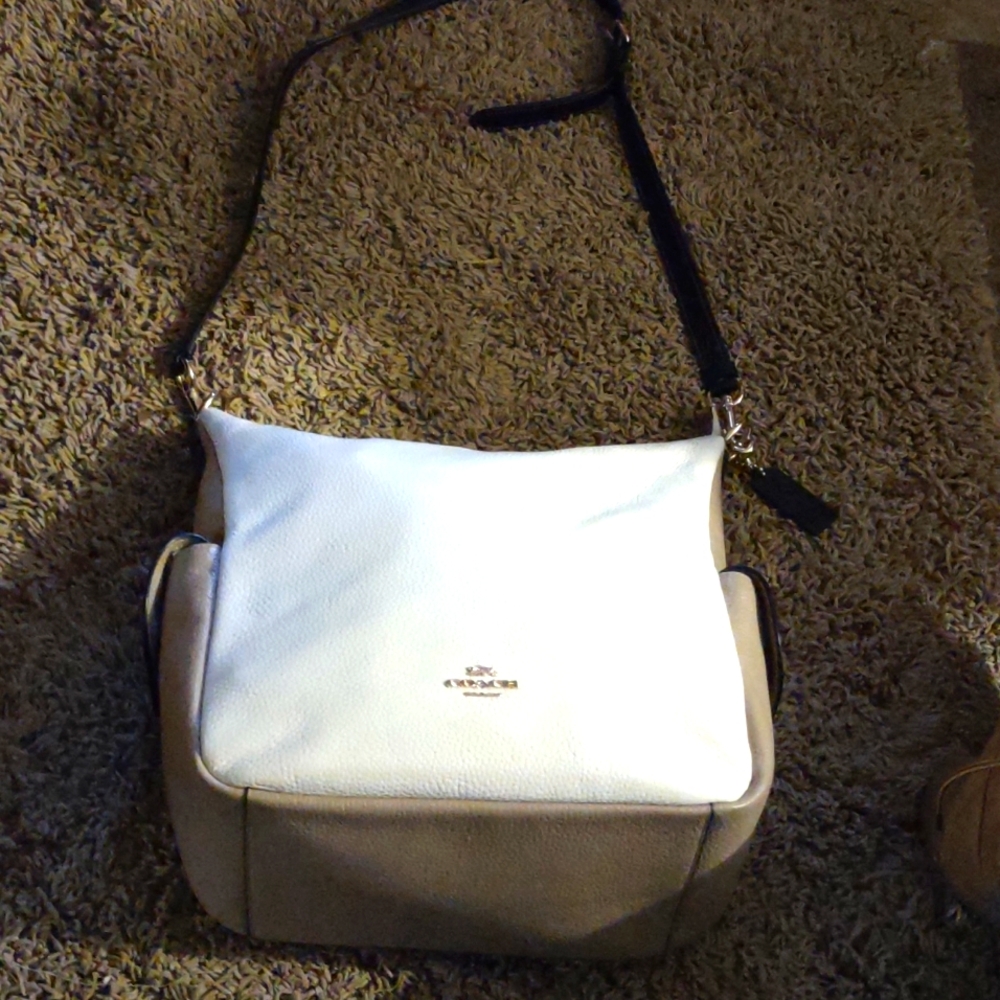 COACH zipper on the back side, and two side pockets that snap not a spot on it .